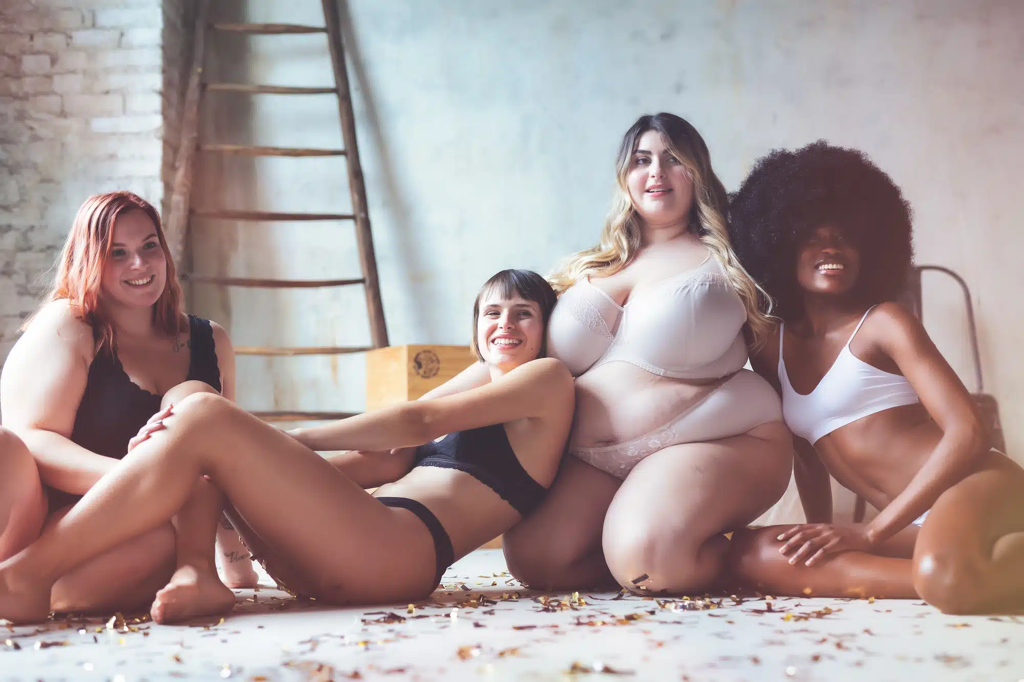Die Ästhetik der menschlichen Körpers. Gruppe von vier Frauen mit unterschiedlichen Körpern, die nackte Dessous tragen und zusammen posieren